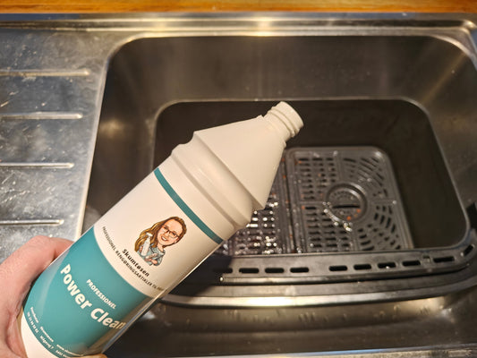 På billeder vises en flaske powerclean fra skumtøsen som er en kraftigt rengøringsmidler til at rengøre en airfryer effektivt men samtidigt er skånsom på teflon belægningerne i en airfryer
